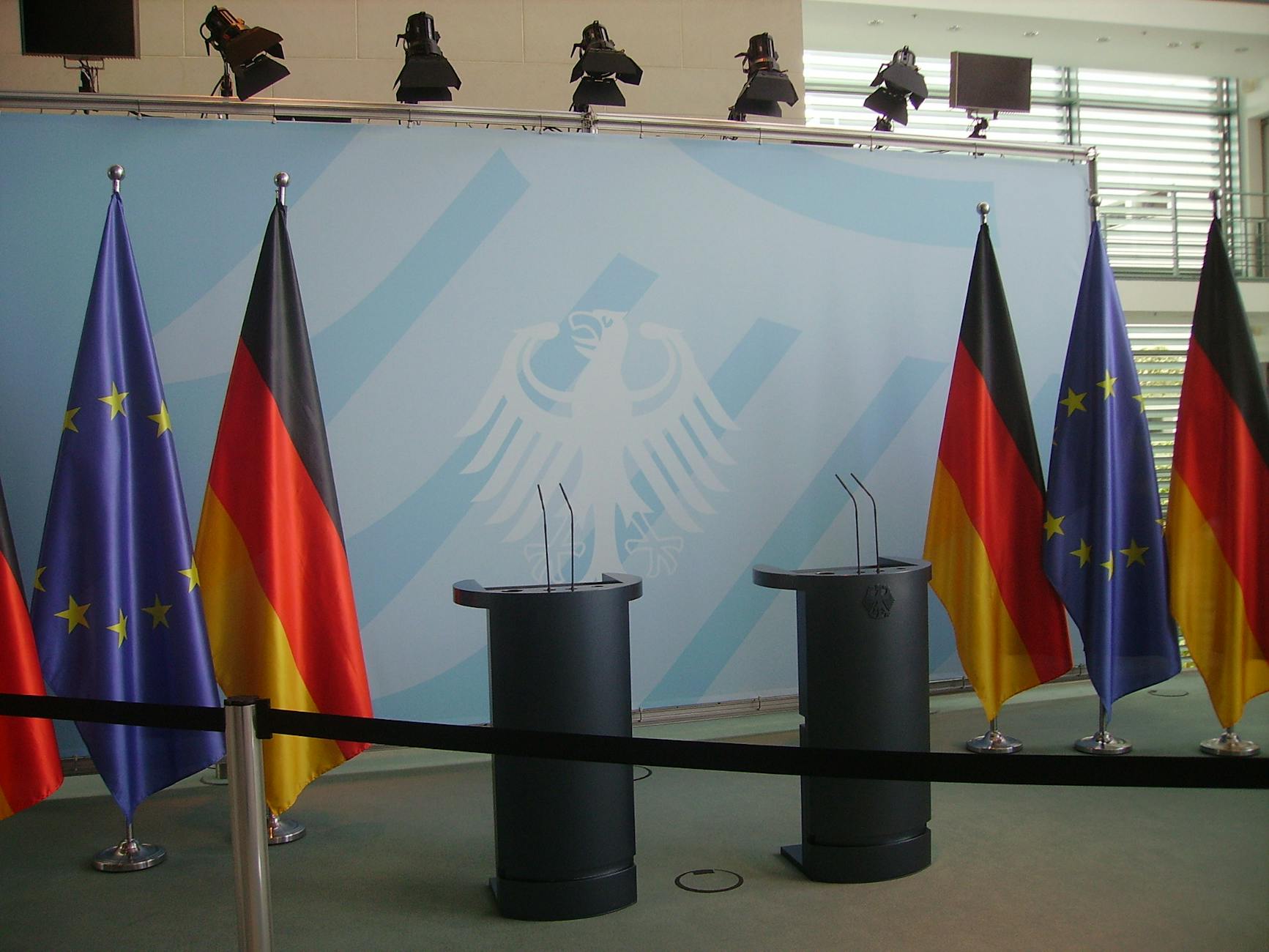 Empty podiums with German and EU flags in Federal Chancellery, Berlin.